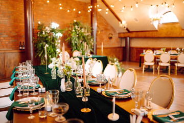 Beautiful decorated table for the event in the restaurant in emerald color. Wedding, birthday, party, event concept.