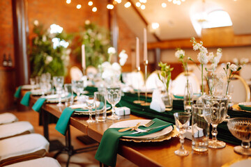 Beautiful decorated table for the event in the restaurant in emerald color. Wedding, birthday, party, event concept.