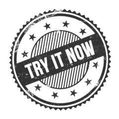 TRY IT NOW text written on black grungy round stamp.