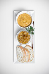 top view of goose liver pate with apple chutneys and bread on white background