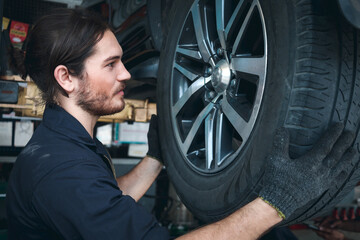 Auto mechanic work in garage, checking wheels, car service technician repairing customer car at...