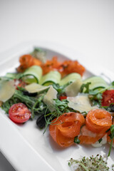 closeup of salad with lightly salted salmon and vegetables on white background