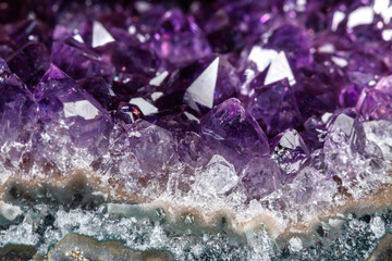 Macro Mineral Stone Amethysts in the rock on a white background