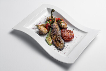 close up of grilled vegetables and champignon on white plate on white background