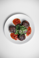 top view of meat beef medallion on tomato and grilled eggplant with salsa sauce