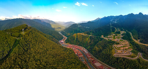 a large aerial panorama of the Mzymta river valley and the hotels of the Rosa Khutor resort, the...