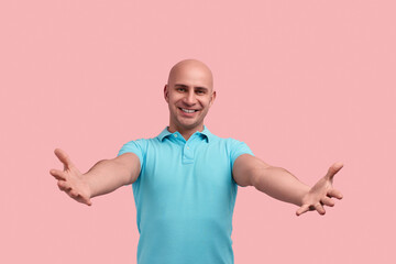 Come and hug me. Happy smiling bald homosexual man with bristle is meeting friend, reaching out...