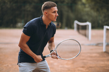 Young man playing tennis at the court