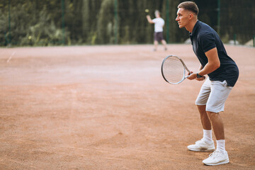 Young man playing tennis at the court