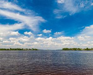 Summer landscape: River, sky, clouds, Church bell tower on the water