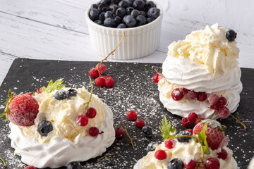 Anna Pavlova cake with currants, blueberries and strawberries
