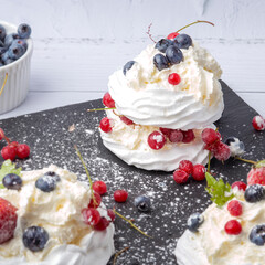 Anna Pavlova cake with currants, blueberries and strawberries
