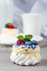 Pavlova dessert with raspberry, blueberry, and mint.