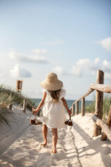 Little girl walking on the beach on a summer day