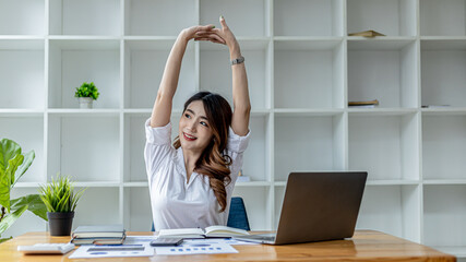 Asian working woman relaxing, a businesswoman in office, she is relaxing after working hard for a long time, causing fatigue and stress to take a break, she has office syndrome . Hard work concept.