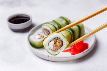 sushi rolls with cucumber  ginger soy sauce on white background