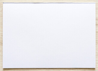 Watercolor paper texture on wood background with clipping path. White paper sheet with a torn edges.