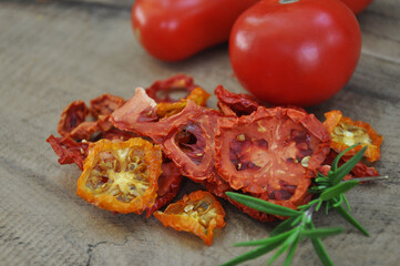 Dried tomato. A slide of sun-dried tomatoes which lie on a wooden background. flat top view. Freeze-dried vegetables. Dried spices healthy food. Spices. Sun-dried Italian tomato. Rosemary.