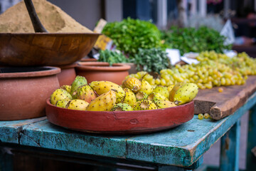 A bowl of ripe cactus fruit on a blue table