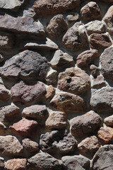Full frame close-up view of a part of an old outdoor wall made of rocks and stones