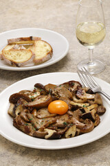 Fototapeta na wymiar grilled mushrooms (porcini, shiitake, and eryngii ) with egg yolk, Spanish tapas