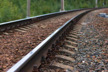 Railway rails and sleepers close-up. A railway that goes around a bend in the distance.