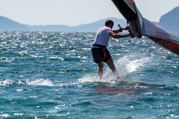 Naklejka premium Hyeres, Almanarre beach, France, July 10, 2021. Extreem water sport - wing foil, kite surfing, wind surfindg, windy day on Almanarre beach near Toulon, South of France