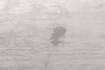 Shabby wall of an old house with uneven crumbling plaster. Yellow-gray abstract texture.