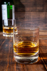 Glasses of strong scotch single malt whisky served on dark wooden table in old pub