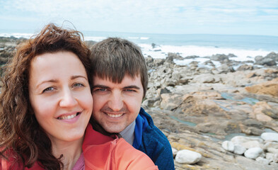 Fototapeta na wymiar Selfie of a young attractive tourist couple near the ocean promenade.