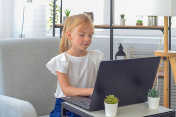 back to school. little girl student doing homework on a laptop. distance learning concept