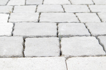 Concrete or paved newly laid gray paving slabs or stones for floors or walkways. Concrete paving slabs in the backyard or road paving. Garden brick path in the courtyard on a sandy foundation.