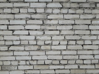 White brick wall made by a layman from old broken bricks.
