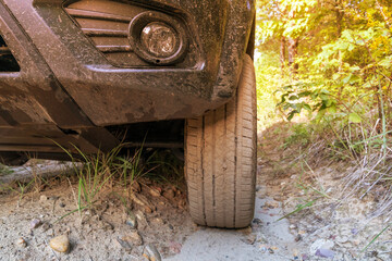 an SUV on a forest road climbs uphill