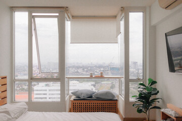 Real life cozy minimal loft bedroom in small apartment with city view.