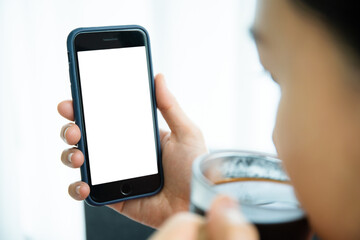 Mockup smartphone with isolated blank screen. Young Asian woman texting and exploring social media.