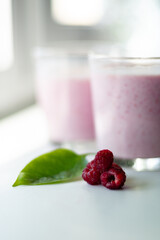 Cream with raspberries. Before making a milkshake of milk and berries. Raspberries with milk. A milkshake in a glass. Front view. Glasses with a cocktail.