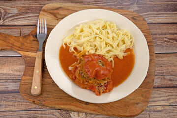 tomate farcie et tagliatelles dans une assiette