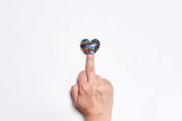Fuck love. Middle finger and heart shape balloon. Hand of person showing fuck handgesture over white backgrounbd