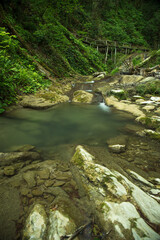 Naklejka na ściany i meble Waterfall in the rainforest. Stormy mountain river.