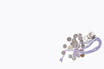 Concept of islamic finance on white background. Sharia-compliant finance - banking or financing activity. Coins and praying beads. Zakat, islamic banking