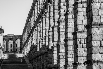 Columnas del acueducto de Segovia con la escalera de piedra al fondo en blanco y negro.