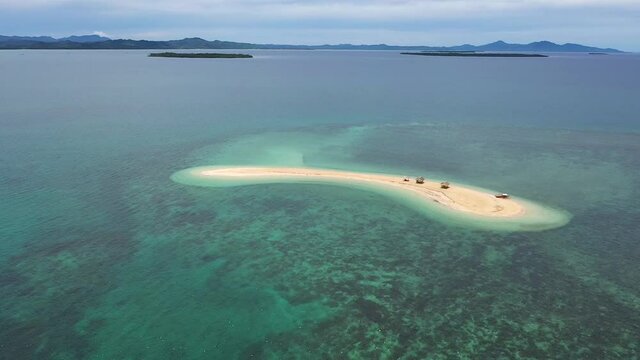 Aerial footage of a small Island, a sand bar in Roxas, Palawan. Summer and travel vacation concept. Tropical islands, top view.Seascape with beautiful sky and islands. Turquoise sea with coral reefs. 