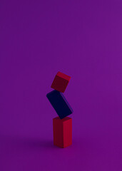 Geometric 3D shapes in vertical composition photographed with purple light. Creative gravity concept.