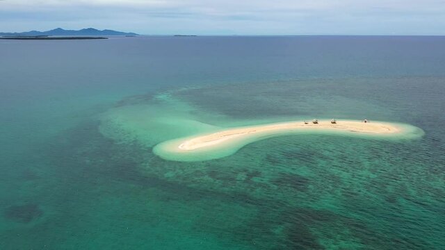 Aerial footage of a small Island, a sand bar in Roxas, Palawan. Summer and travel vacation concept. Tropical islands, top view.Seascape with beautiful sky and islands. Turquoise sea with coral reefs