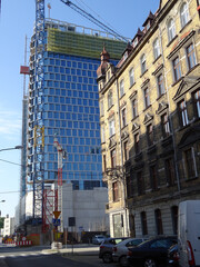 scyscraper construction and old houses