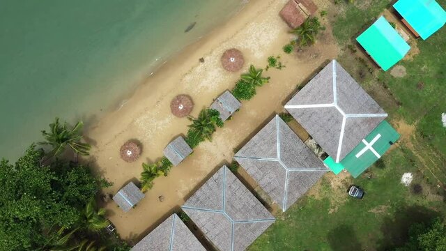 Cinematic shot , aerial view of a resort on the coast, white sand beach, bungalows in Roxas, Palawan. Summer and travel vacation concept. Tropical islands, top view. Seascape with Turquoise sea 