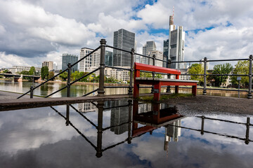 Frankfurt, Germany - June 4, 2021: the famous red bench in front of the frankfurt skyline at the...
