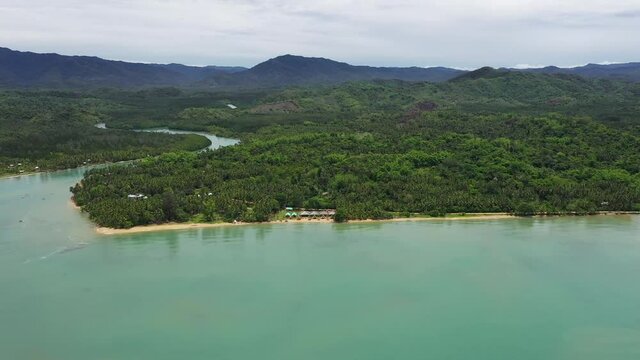 Cinematic shot , ascending aerial drone view of the coast, white sand beach in Roxas, Palawan. Summer and travel vacation concept. Tropical islands, top view. Seascape with beautiful sky, 