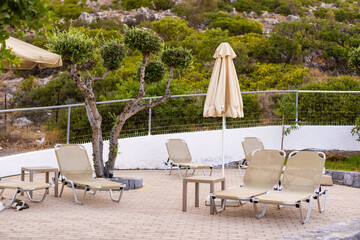 Two loungers next to a swimming pool.